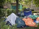 Tents and personal belongings fill the front yard of the recently condemned River Place in Sandwich Town on Thursday, Aug. 5, 2021, as evicted tenants scramble to find a place to live.