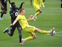 Nashville SC defender Alistair Johnston crosses after beating CF Montreal defender Mustafa Kizza during the first half at Nashville's Nissan Stadium on April 24, 2021.