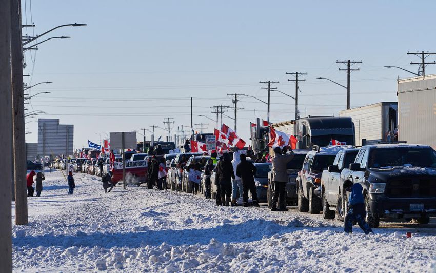 Supporters of truck drivers protesting the COVID-19 vaccine mandate cheer on a convoy of trucks on their way to Ottawa, on the Trans-Canada Highway west of Winnipeg on Jan.  25.