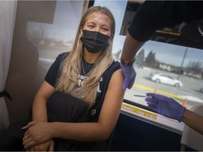 Paris Dubowski, 20, gets her booster shot on the provincial GO-VAXX Bus outside Tecumseh Arena and Recreation Complex on Tuesday.