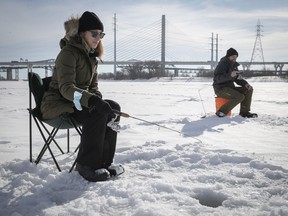 Marie-Eve Senecal and Guillaume Paquette try their luck at ice fishing along the Seaway near the Champlain Bridge in Longueuil.