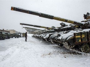 A Ukrainian Military Forces serviceman stands in front of tanks of the 92nd separate mechanized brigade of the Ukrainian Armed Forces, parked in their base near Klugino-Bashkirivka village, in the Kharkiv region on Jan. 31.