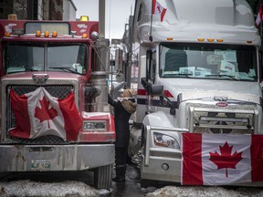 A woman greets a truck driver and the vehicles lined streets in Centretown Sunday afternoon.