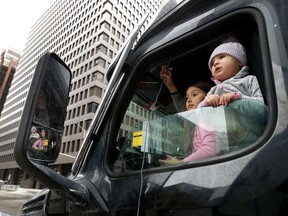 Children peered out of a truck's cab.