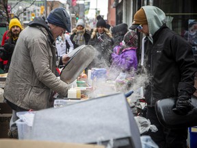 People gathered in Downtown Ottawa during the Freedom Convoy protest, Sunday, Feb. 6, 2022. Food stations with bbq's and hot soup and various other food items were set up throughout the protest area, including at Bank and Slater streets on Sunday.
