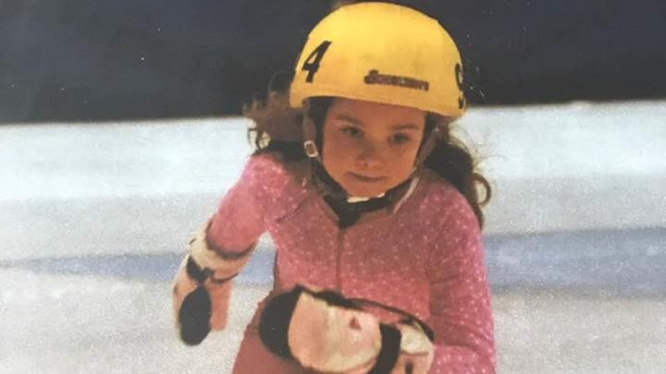 Jeune fille patinant avec un casque.