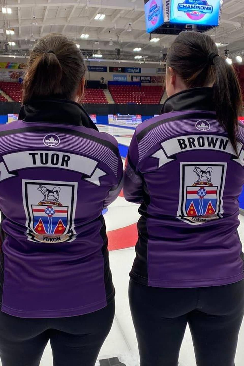 Deux femmes de dos portant le chandail de curling du Yukon. 