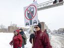 Neighborhood resident Ronald Daignault holds a placard showing his opposition to the REM de l'Est during a media briefing by project planners CDPQ Infra at Georges-V and Dubuisson Aves.  in east-end Montreal on Tuesday January 25, 2022.