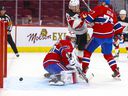 Canadiens goaltender Cayden allows a second-period goal while Habs defenseman Brett Kulak ties up Devils' Andreas Johnsson Tuesday night at the Bell Centre.