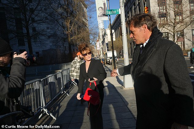Palin and Ron Duguay reach out to hold hands as they arrive at Federal Court on the seventh day of her trial against the New York Times