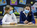 Grade 4 students Mathilde Benjamin, left, and Béatrice O'Doherty wear masks while working together in class at John Caboto Academy on Monday March 8, 2021.