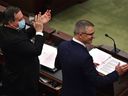 Le premier ministre Jason Kenney (à gauche) applaudit après que le ministre des Finances Travis Toews a annoncé un budget équilibré lors de la présentation du budget de l'Alberta de 2022 dans les chambres de l'Assemblée législative de l'Alberta à Edmonton, le 24 février 2022. 