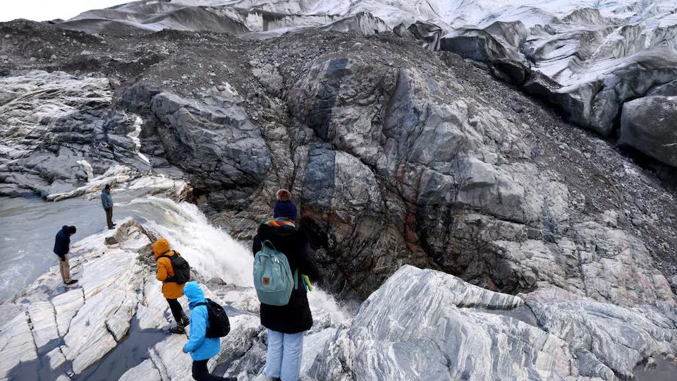 Des touristes observent ce qu'il reste d'un glacier.