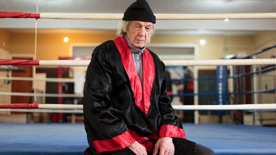 André Pellan assis près d'un ring de boxe dans un salle de sport.
