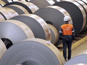 An ArcelorMittal employee looks at coils of steel treated by galvanization.