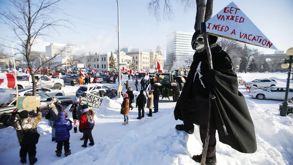 Des contre-manifestants aux opposants à l'obligation vaccinale devant le Palais législatif du Manitoba à Winnipeg, le 4 février 2022.
