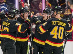 Vancouver Canucks defenseman Quinn Hughes (43) and forward JT Miller (9) and forward Bo Horvat (53) and forward Brock Boeser (6) and forward Elias Pettersson (40) celebrate Miller's first goal of the game against the Calgary Flames in the second period at Rogers Arena on Feb. 24, 2022.