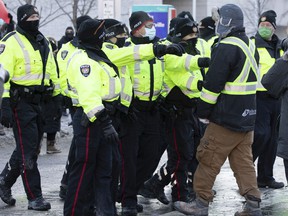 La police d'Ottawa retire un manifestant anti-mandat de la foule contre-manifestante le samedi 5 février 2022.