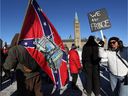 A supporter carries a US Confederate flag during the Freedom Convoy protesting COVID-19 vaccine mandates and restrictions in front of Parliament on January 29, 2022 in Ottawa.