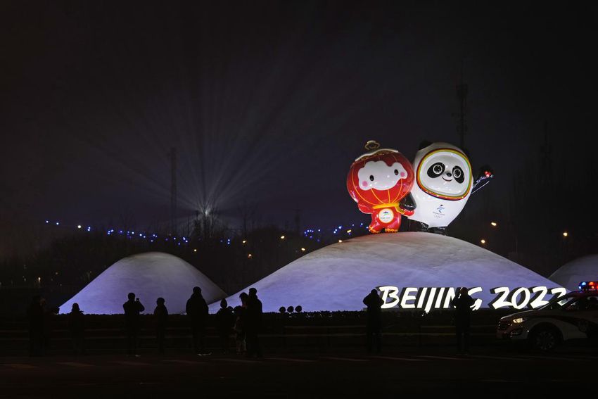 Residents past near the Paralympic mascot Shuey Rhon Rhon left, and Winter Olympic mascot Bing Dwen Dwen displayed near the iconic Bird's Nest stadium where a rehearsal for the opening ceremony of the 2022 Beijing Games took place Sunday.