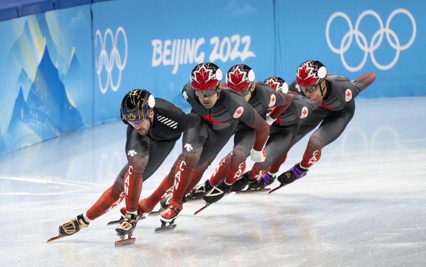 Canada's Charles Hamelin, left, and Maxime Laoun lead the team around the track during a short track speed skating practice session at the 2022 Winter Olympics in Beijing on Tuesday.