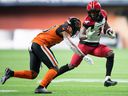 Calgary Stampeders' Hergy Mayala runs with the ball before being tackled by BC Lions' Hakeem Johnson in Vancouver, on Oct. 16, 2021.