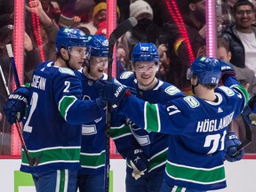 Canucks linemates Elias Pettersson, Vasily Podkolzin and Nils Höglander (second from left to right) celebrate Pettersson's goal against the Arizona Coyotes on Tuesday at Rogers Arena with blueliner Luke Schenn (far left).