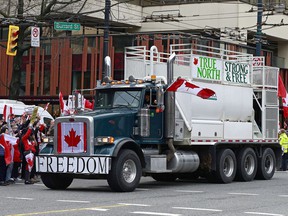 A flag-bedecked truck drives along Burrard Street amid anti-vaccination policy protests in downtown Vancouver last Saturday.