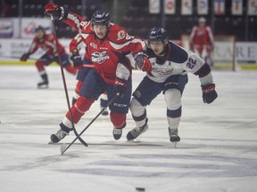 Windsor Spitfires' forward Christopher O'Flaherty and Saginaw's Mitchell Smith race down the puck during Thursday's game at the WFCU Centre.