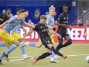 CF Montréal's Djordje Mihailovic, center, takes a shot on goal as Philadelphia Union players defend during second half MLS soccer action in Montreal on Saturday, March 5, 2022.