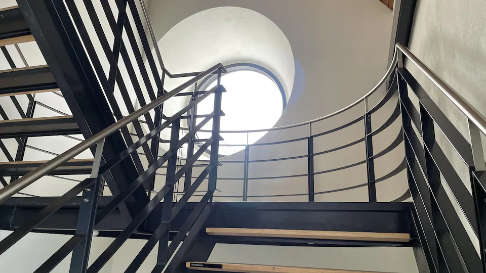 Une fenêtre ronde dans une cage d'escalier.