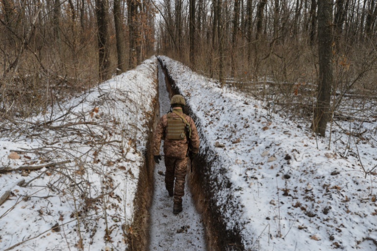 Un militaire ukrainien marche le long des positions de combat sur la ligne de contact avec les rebelles séparatistes soutenus par la Russie près de la ville d'Avdiivka dans la région de Donetsk, en Ukraine