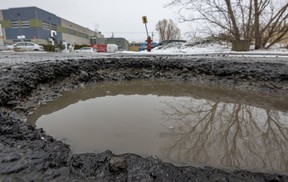 A pothole is half full of water on 54th Ave. in the Lachine borough of Montreal on Monday March 7, 2022.