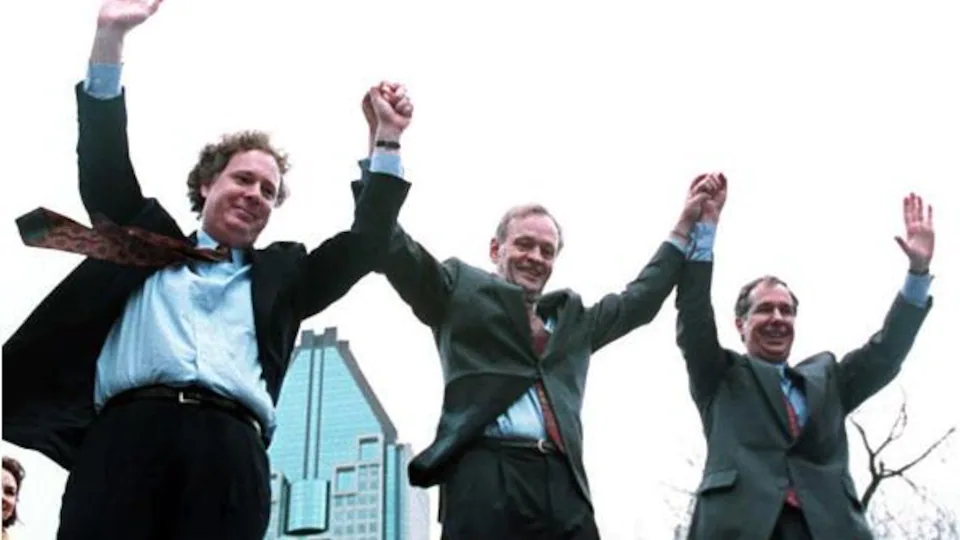 Jean Charest, alors qu'il était chef du Parti conservateur du Canada, lève les bras au ciel avec Jean Chrétien, alors premier ministre du Canada et Daniel Johnson, chef de l'opposition au Québec