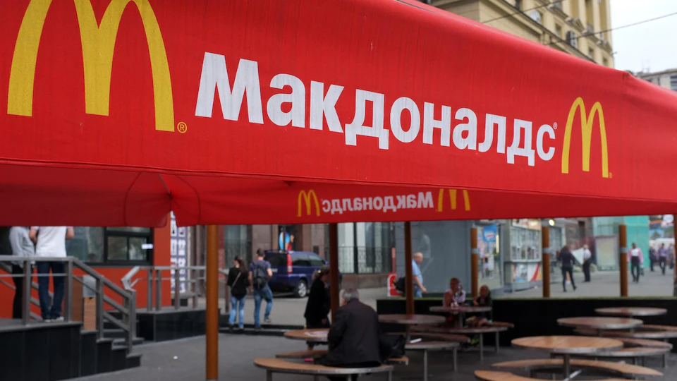Des gens sont assis à des tables sur la terrasse du premier restaurant McDonald's à avoir ouvert ses portes en Union soviétique en 1990, à Moscou le 21 août 2014.