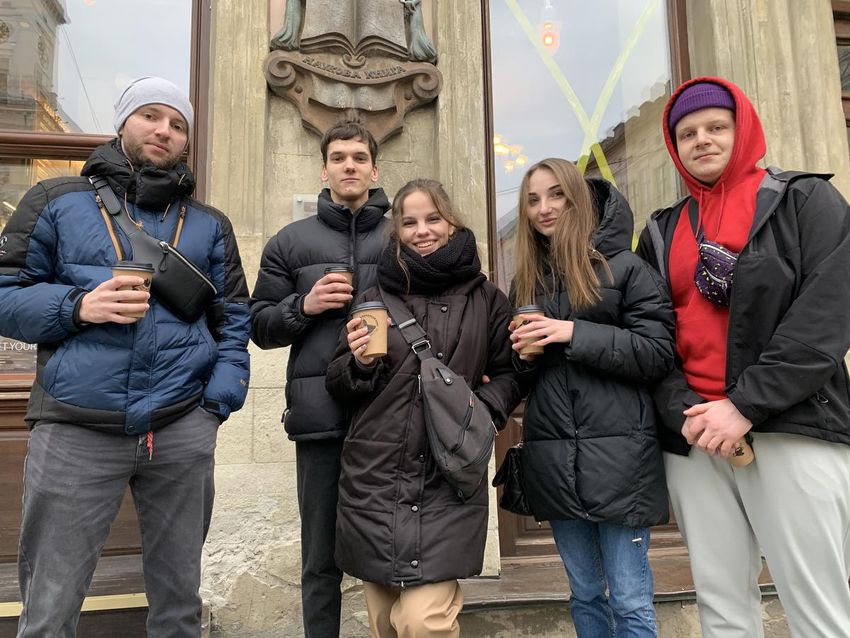 A group of students and young professionals who fled Kharkiv on February 25, 2022 pose outside a coffee shop in downtown Lviv, Ukraine on March 6, 2022 — the first time they've left their hotel rooms since fleeing west.