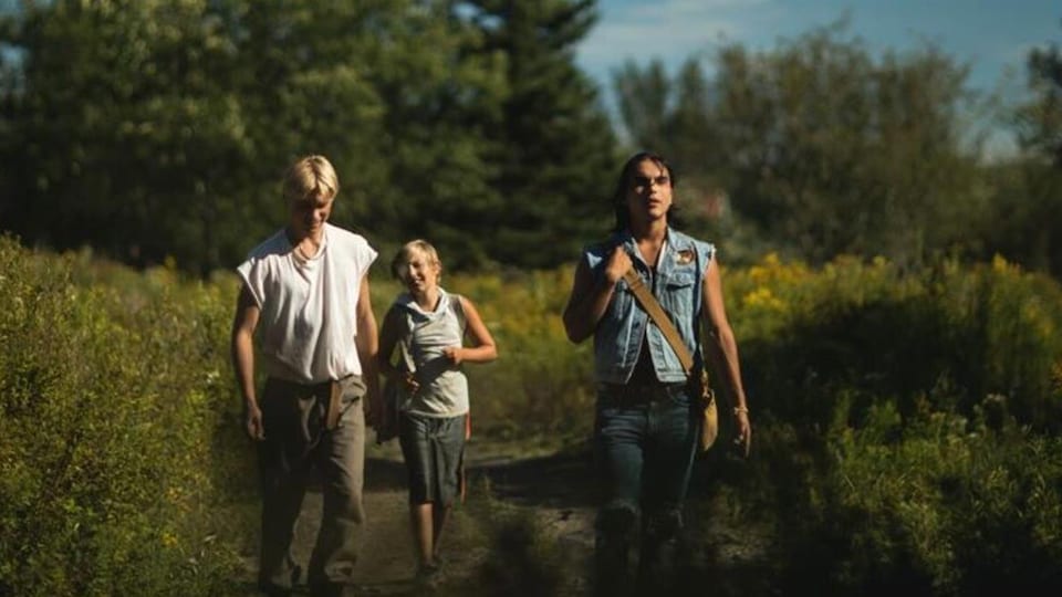 Les trois interprètes du film Wildhood marchent dans une clairière.
