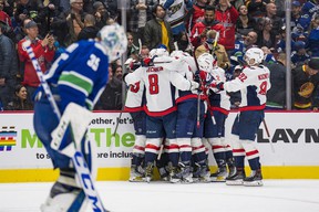 The Washington Capitals celebrate their victory against the Vancouver Canucks at Rogers Arena on Friday as goaltender Thatcher Demko skates off.  The Capitals won 4-3 in overtime.  Photo: Bob Frid-USA TODAY Sports