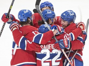 Canadiens' Nick Suzuki, right, celebrates with teammates after scoring against the Seattle Kraken during third period NHL hockey action in Montreal on Saturday, March 12, 2022.