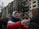 Une femme pleure devant des immeubles d'habitation détruits à la suite d'un bombardement russe sur le quartier nord-ouest d'Obolon à Kiev, en Ukraine, le 14 mars 2022.