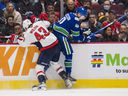 Canucks center Elias Pettersson gets run into the boards by rugged Washington Capitals winger Tom Wilson during last Friday's game at Rogers Arena.  Pettersson has been out of the Canucks lineup since the Capitals game with an undetermined upper-body injury.
