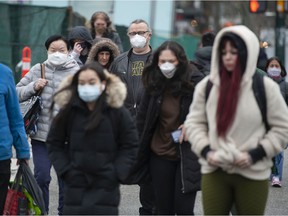 People wear masks to guard against COVID-19 in Vancouver on March 11, 2022.