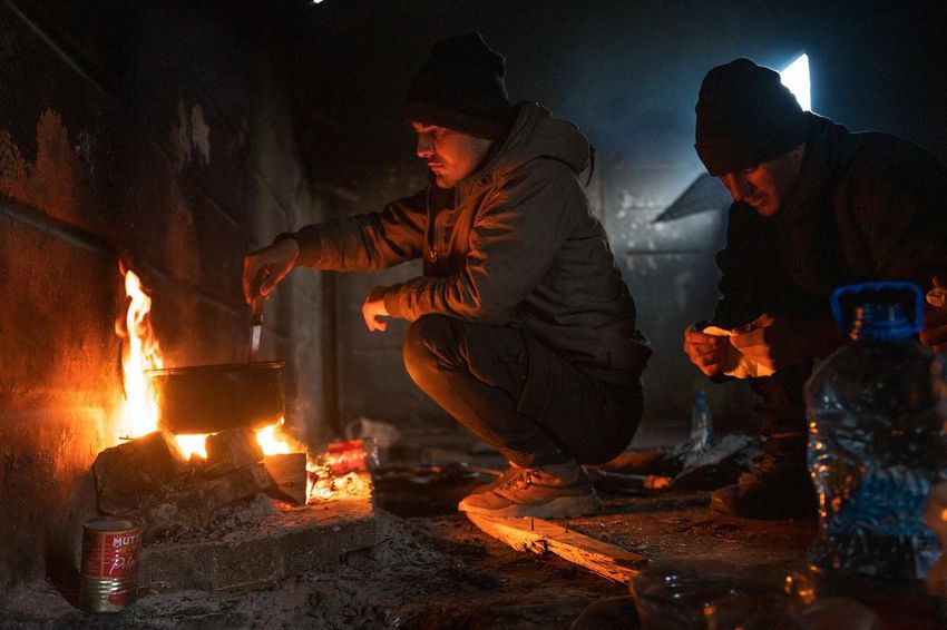 Abbas, 16 and Shaardul, 16, both from Jalalabad, Afghanistan, cook bread over a fire in an abandoned boxcar at a train station near Sombor, Serbia on March 9, 2022.