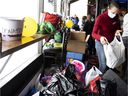 Volunteers sort a steady stream of donations bound for Ukraine as Montrealers drop items off at Duffy's in Dorval on Sunday.