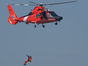 A US Coast Guard helicopter crew rescues a woman kayaker from Peche Island on Wednesday, March 17, 2020.