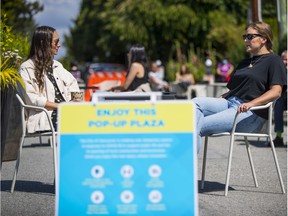 Neighborhood residents Kyla Jamieson, left, and Emma Simms enjoy the pop-up plaza at West 14th Avenue and Granville Street in 2020.