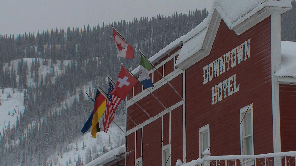 Façade de l'hôtel en hiver avec des drapeaux de différents pays au vent.