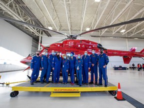 Members of the flight crew along with Alberta business and community leaders take a group picture before being airlifted by helicopter to a remote location in Devon where they must raise enough money to secure their flight back to the airport.  Taken on Thursday, March 24, 2022, in Edmonton.Greg Southam-Postmedia