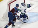 Vancouver Canucks goaltender Jaroslav Halak, right, makes a glove save as Colorado Avalanche right wing Valeri Nichushkin watches during the first period of an NHL hockey game Wednesday, March 23, 2022, in Denver.