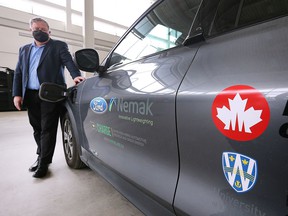 Peter Frise, Director of the Center for Automotive Research and Education at the University of Windsor is shown with a Ford Mach-E electric vehicle at the faculty of engineering building on Friday, March 25, 2022.